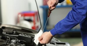 Mechanic checking car engine oil level